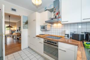 een keuken met witte kasten en een aanrechtblad bij Constantin in Tinnum