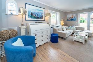 een woonkamer met een blauwe stoel en een bank bij Constantin in Tinnum