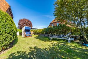 een tuin met een bank en een stenen muur bij Constantin in Tinnum