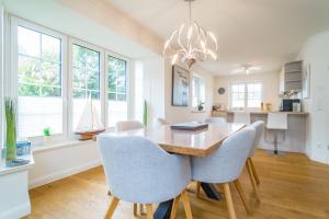 a dining room with a wooden table and chairs at Gode Stuv in Westerland