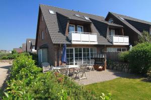 a house with a table and chairs in the yard at Friesenjung in Wenningstedt