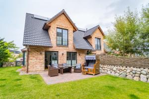 a brick house with a patio and a stone wall at Gode Stuv in Westerland