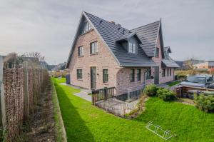a large brick house with a black roof at Hoogen Hüs in Westerland