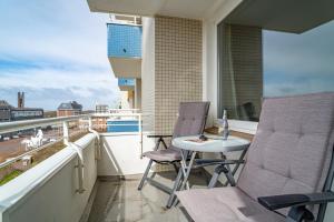 einen Balkon mit 2 Stühlen und einem Tisch auf einem Gebäude in der Unterkunft Seestern in Westerland