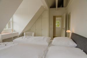 Cette chambre comprend 2 lits blancs dans un escalier. dans l'établissement Wandafül Hüs, à Westerland