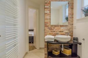 La salle de bains est pourvue d'un lavabo et d'un mur en briques. dans l'établissement Wandafül Hüs, à Westerland