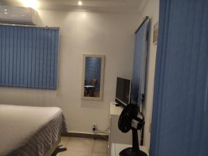 ein Hotelzimmer mit einem Bett und einem TV in der Unterkunft Lindo quarto c/ banheiro privativo in Jaú
