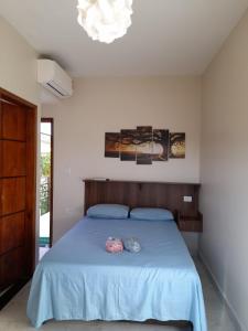 Un dormitorio con una cama con sábanas azules y una lámpara de araña. en Pousada Reis Guarujá en Guarujá
