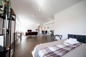 a bedroom with a bed and a living room at G59 LOFTS l Zona Stazione Centro l Netflix & Wi-Fi Fibra l in Parma