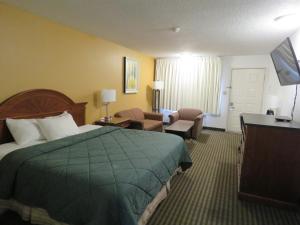 Habitación de hotel con cama y sala de estar. en Thunderbird Motel, en Elko