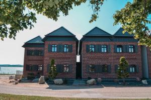 a red brick building with two gambrel at Chalet Möwenblick Rügen mit Meerblick, Sauna und Kamin in Alt Reddevitz