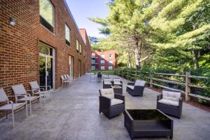 a patio with chairs and tables next to a brick building at Holiday Inn Poughkeepsie, an IHG Hotel in Poughkeepsie