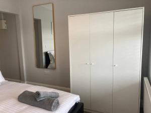 a bedroom with a bed with a mirror and white cabinets at Estuary View Apartment in Kilrush