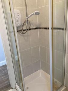 a shower with a glass door in a bathroom at Estuary View Apartment in Kilrush