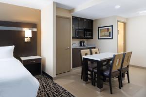Holiday Inn Poughkeepsie, an IHG Hotel في باوكيبسي: غرفة بسرير وطاولة وكراسي