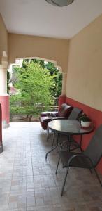 a patio with a table and chairs and a couch at Casa Rosa in Băile Olăneşti