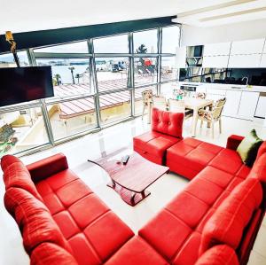 un soggiorno con divano rosso e tavolo di Yaraşır Family Suite a Didim
