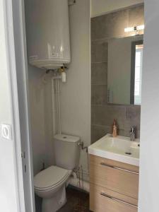 uma casa de banho com um WC e um lavatório em T2 4 pers face gare SNCF Appart Hotel le Cygne 4 em Bourges