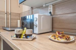 un comptoir de cuisine avec une plaque de cuisson et un four micro-ondes dans l'établissement Pastelle Apartment with own parking place, à Budapest