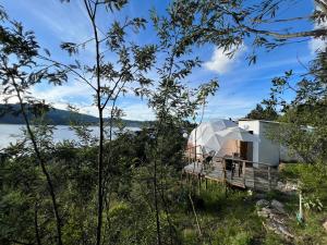 a glass dome house on the side of a lake at Glamping Vista Lago Guatavita in Guatavita