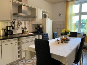 a kitchen with a table with chairs and a tableablish at Chalet Heiderose SPA - Kamin, Sauna & Wellness in Kluis