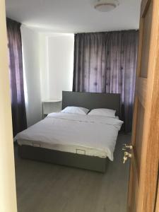 een bed met witte lakens en kussens in een slaapkamer bij Casa Luna in Cluj-Napoca