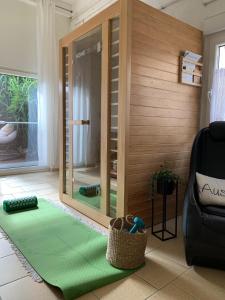 Habitación con espejo y alfombra verde. en Chalet Heiderose SPA - Kamin, Sauna & Wellness, en Kluis