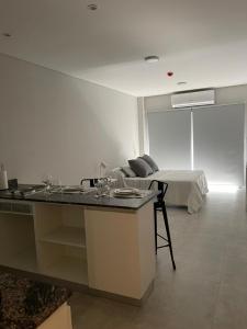 cocina y sala de estar con cama de fondo en Departamento de un ambiente premium en Corrientes en Corrientes