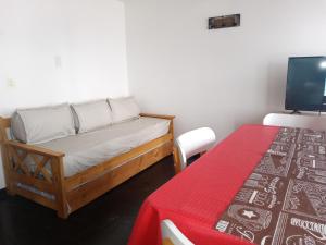 um pequeno quarto com uma cama e uma mesa em LA CASITA DE ALEX em San Carlos de Bariloche