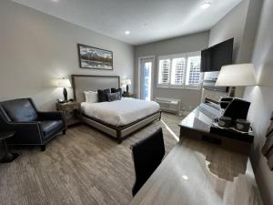 a bedroom with a bed and a desk and a chair at Huff House Inn and Cabins in Jackson