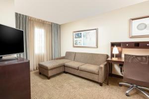 a living room with a couch and a television at Staybridge Suites Chandler, an IHG Hotel in Chandler