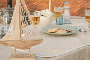 a table with a plate of cookies and glasses of wine at Casa da Isabel - Centro da Nazaré in Nazaré
