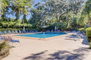 ein Swimmingpool mit blauen Stühlen und vielen Offizieren in der Unterkunft King Queen Sleeper Sofa Updated Luxury Kitchen Bikes & Beach Gear included in Hilton Head Island