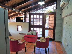 a living room with two chairs and a red couch at La Cascada in Posadas