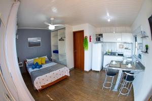 a small room with a bed and a kitchen at Residencial Paraíso da Gamboa in Garopaba +22 photos