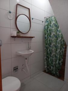 a bathroom with a mirror and a sink at Chalé Penedo Charmosa in Penedo