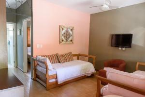 um quarto com uma cama e uma televisão na parede em Hotel Recanto da Cachoeira em Socorro