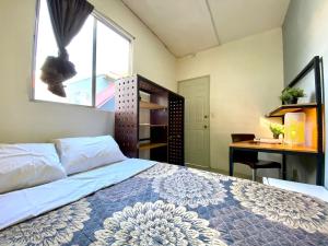 a bedroom with a bed and a desk and a window at ROOMIES HOSTEL Parque México in Mexico City