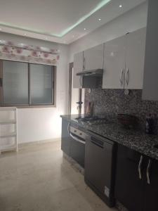 a kitchen with white cabinets and a counter top at Ap 2ch city centre parking en face Hilton a cote du plage in Tangier