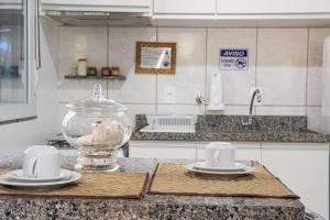 a kitchen counter with a glass bowl on a cutting board at Residencial Paraíso da Gamboa in Garopaba