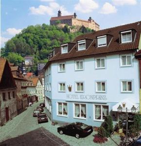 un grand bâtiment bleu dans une ville avec un château dans l'établissement Hotel Kronprinz, à Kulmbach