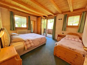 um quarto com 2 camas numa casa de madeira em Bait Ables em Livigno