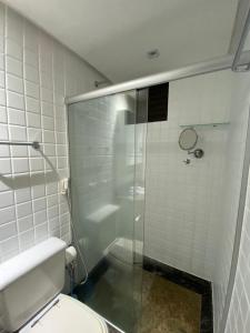 a bathroom with a toilet and a glass shower at Charmoso Flat Lake Side in Brasilia