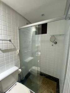 Un baño con inodoro y ducha de cristal. en Charmoso Flat Lake Side, en Brasilia