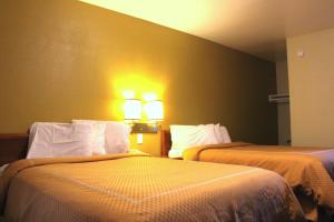 Zimmer mit 2 Betten und 2 Leuchten an der Wand in der Unterkunft Echo Lodge in West Sacramento
