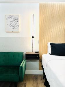 阿馬里洛的住宿－The Westerner - Extended Stay，一间卧室配有一张床和一把绿色椅子