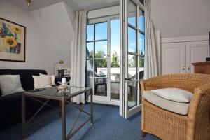 een woonkamer met een bank, een tafel en een stoel bij Witt Hingst App 10 in Tinnum