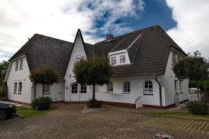 een wit huis met een gambrel dak bij Witt Hingst App 10 in Tinnum