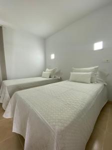 twee bedden in een kamer met witte muren bij Apartamento Pocillos Mimosas in Puerto del Carmen