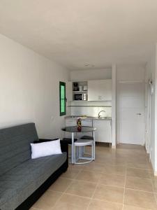 een woonkamer met een bank en een tafel bij Apartamento Pocillos Mimosas in Puerto del Carmen